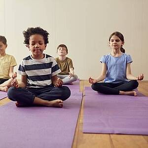 Kinder meditieren auf Yoga-Matten Kinder meditieren auf Yoga-Matten