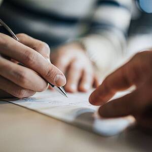 Unterschrift unter Vertrag Detailaufnahme von Händen die einen Vertrag unterschreiben